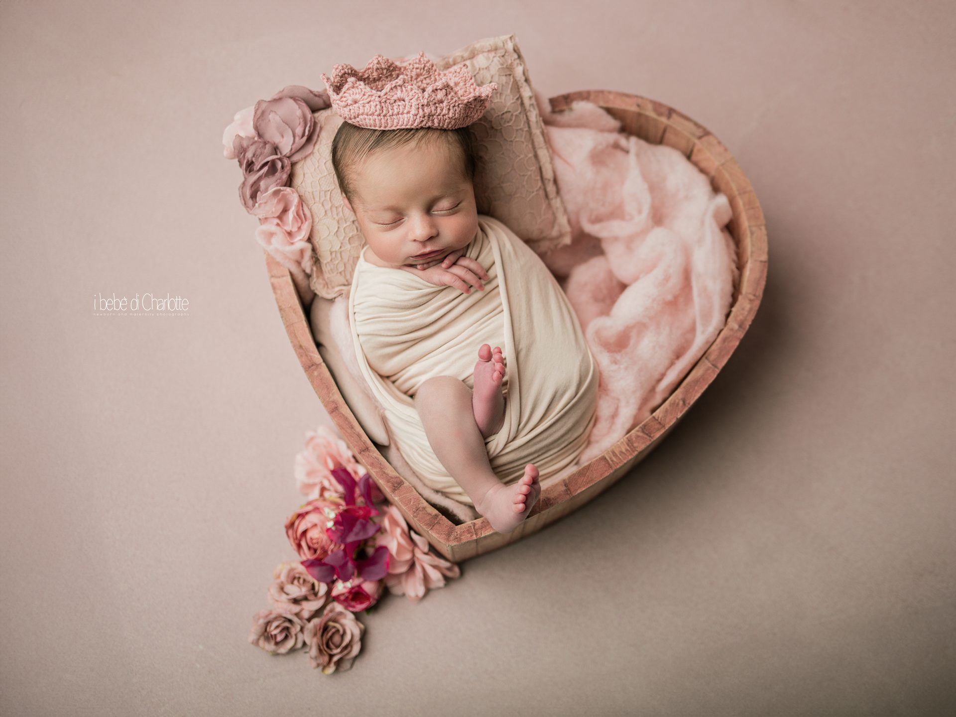 Neonata con coroncina che dorme in una culla di legno a forma di cuore — fotografia newborn