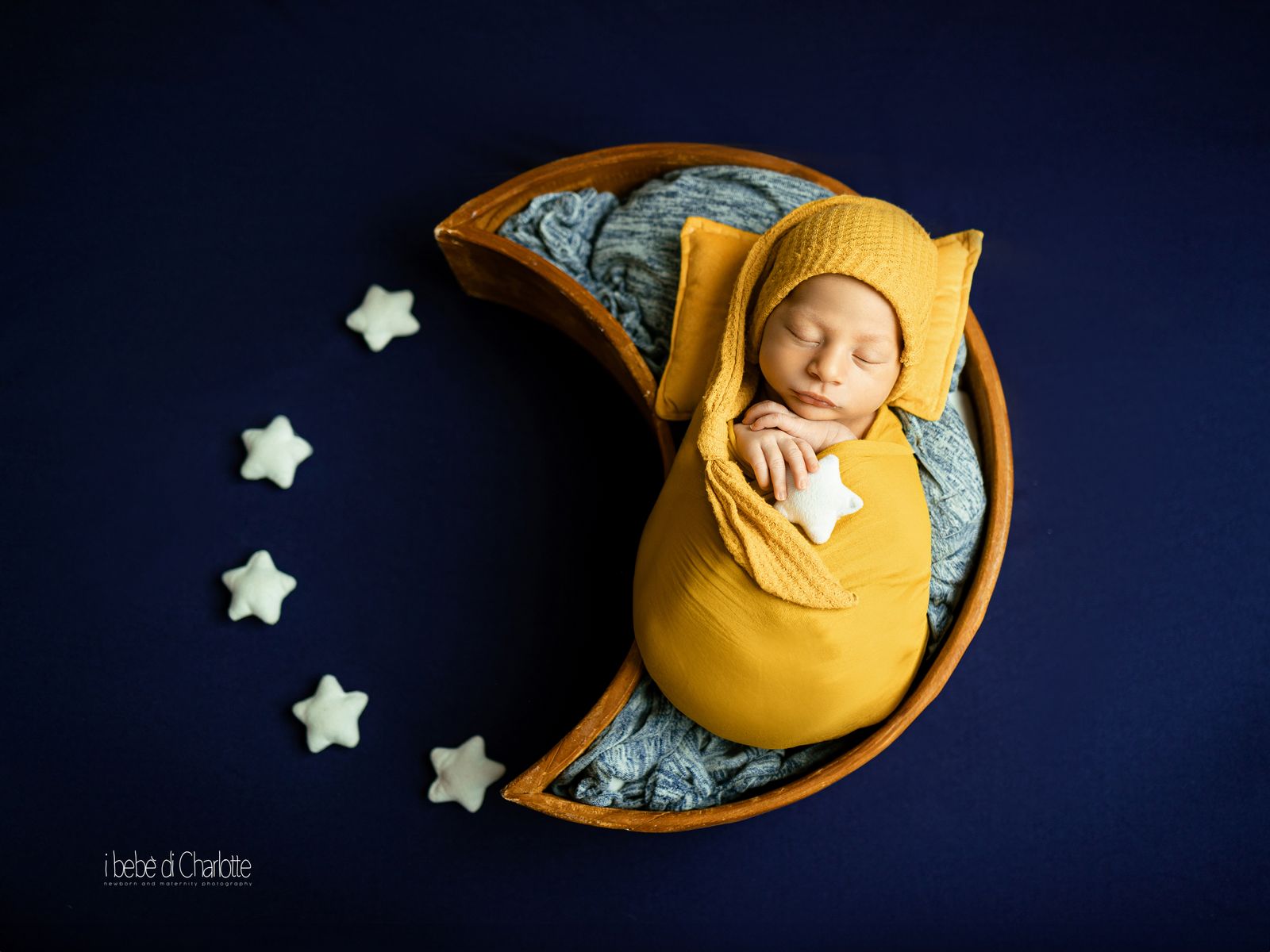 Neonato che dorme su una luna di legno con stelle bianche