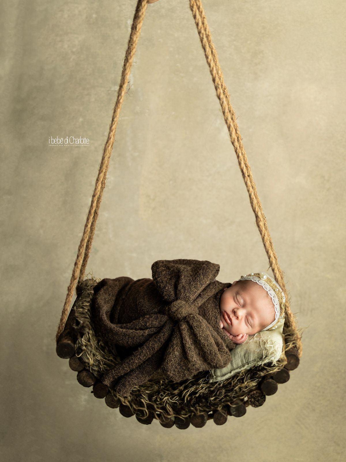 Neonata che dorme su un'altalena sospesa